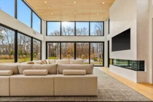 A spacious, elegant living room with large black-framed European windows and a modern patio door. The installation provides abundant natural light and seamless indoor-outdoor flow. The high-performance glass enhances energy efficiency while adding a luxurious architectural element.
