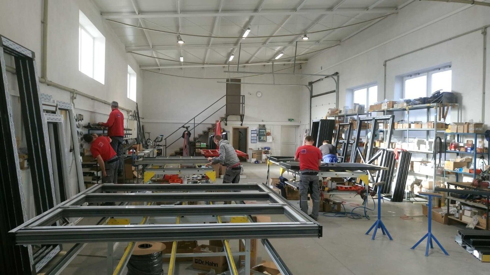 Technicians and workers building aluminum window frames in an organized workshop